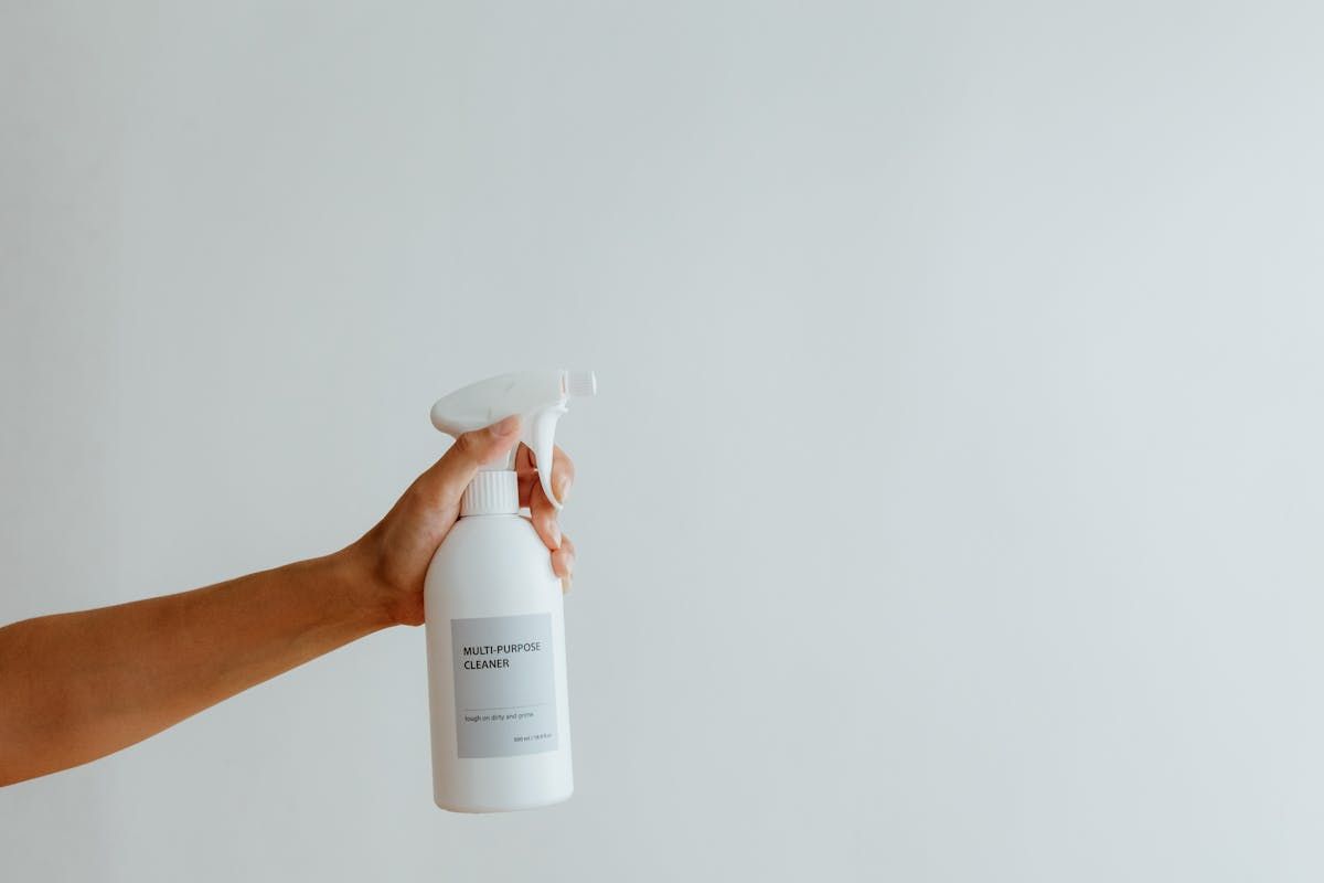 Close-up of a hand holding a multi-purpose cleaner spray bottle