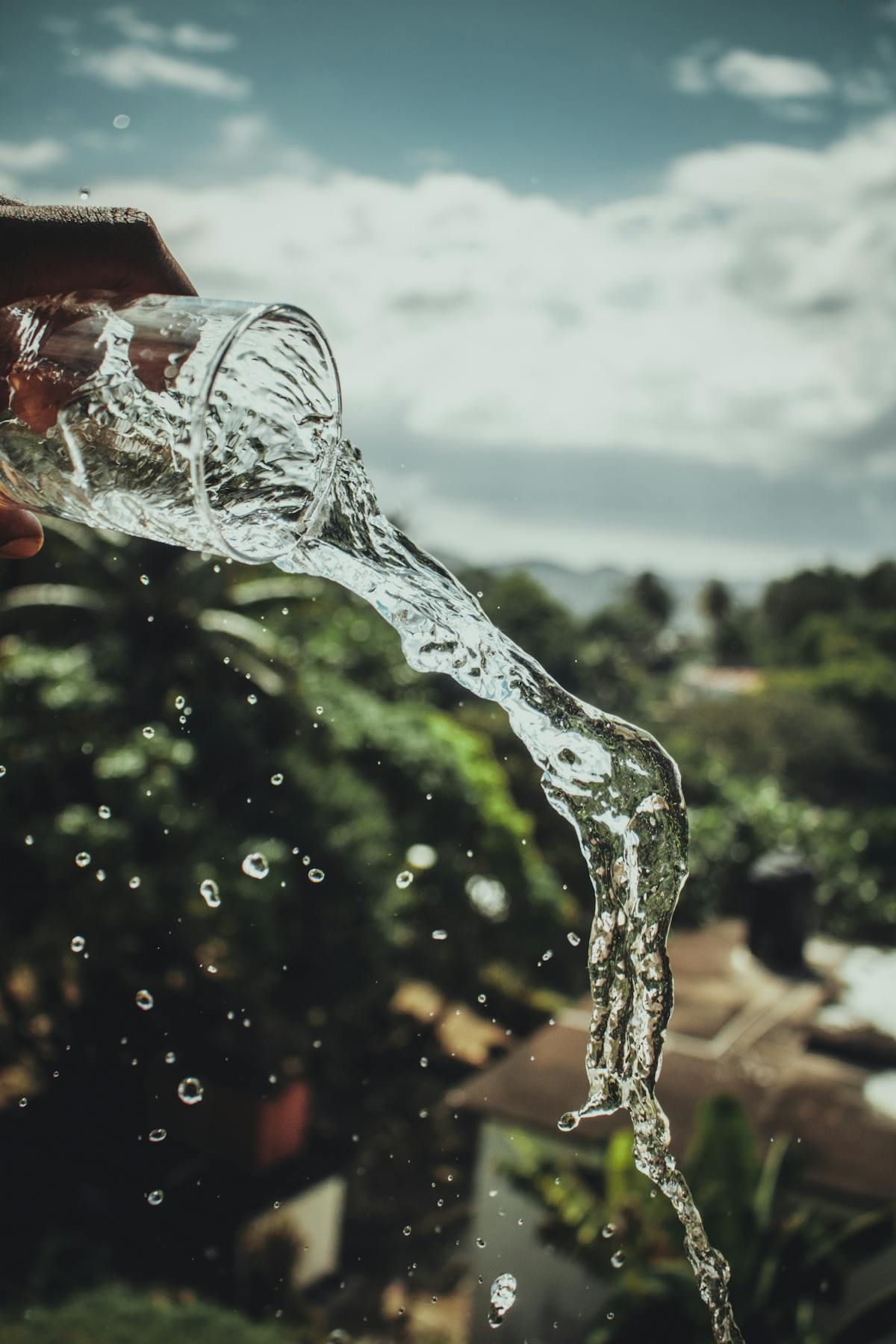 Crystal clear water pouring from a glass in natural light